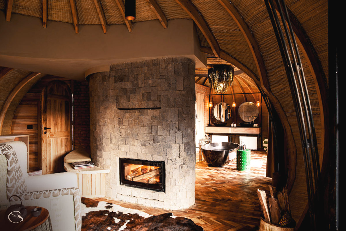 A room's private lounge with fireplace opening on to a dressing area and bathroom